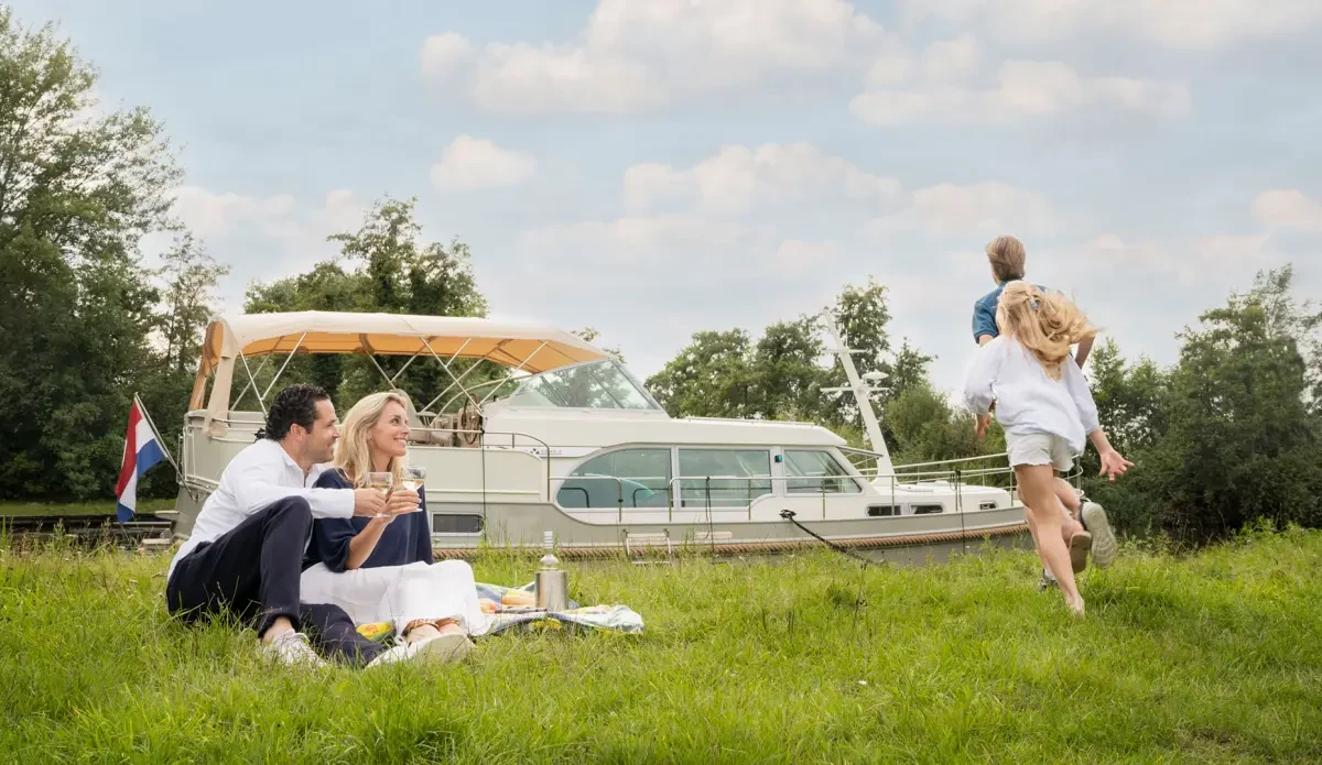 A family enjoying a relaxed picnic beside their Linssen yacht