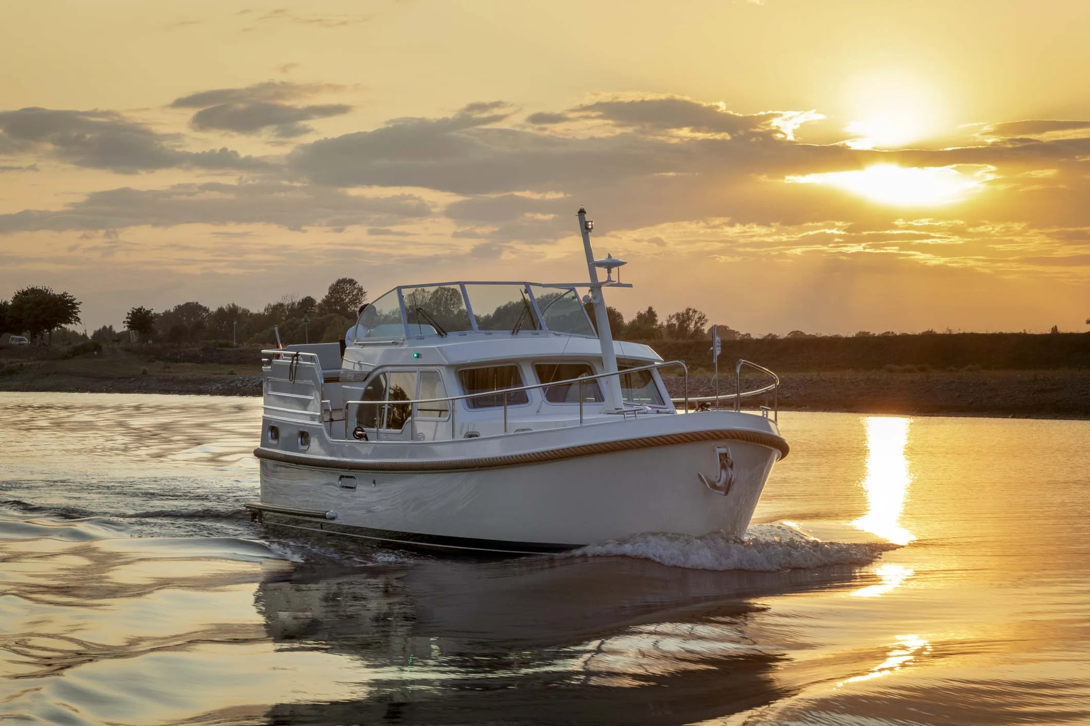 A Linssen yacht enjoying a tranquil cruise as the sun sets over the water